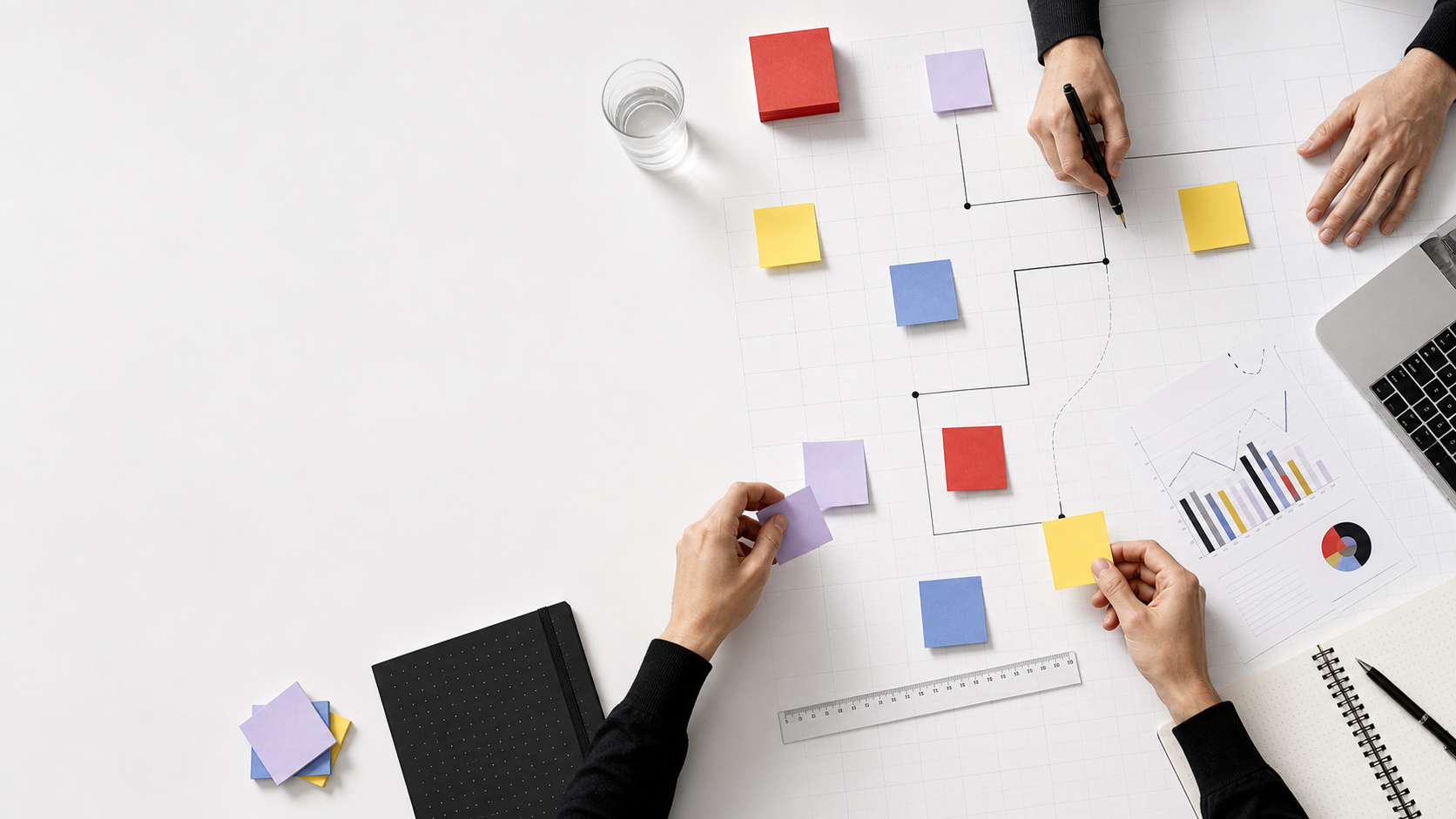 Swiss workshop table with hands arranging colored notes on a technical decision blueprint.